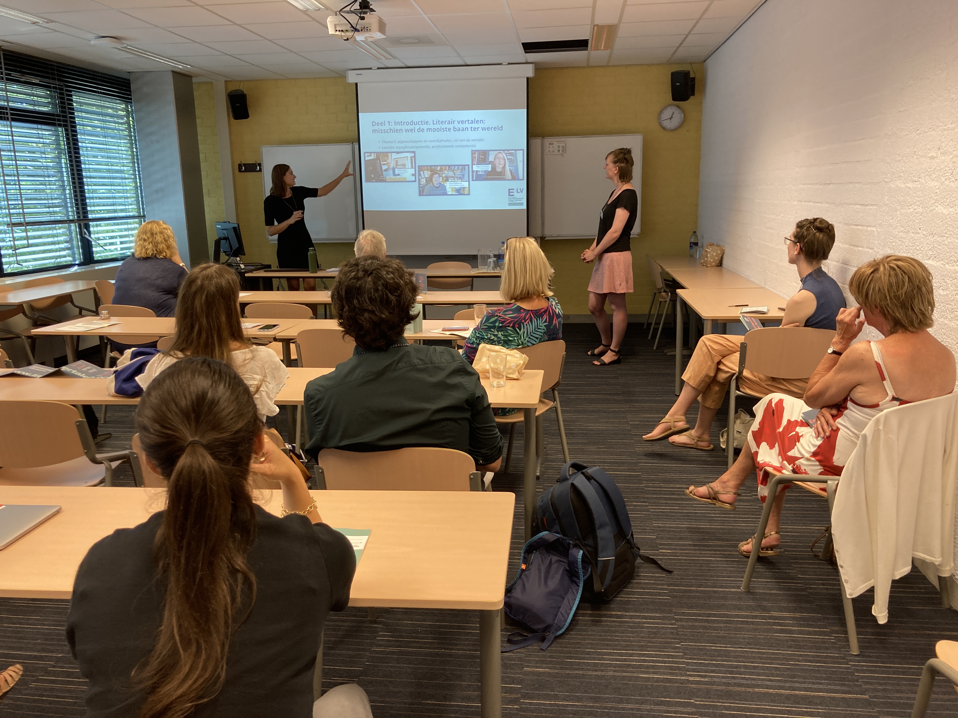 Foto van medewerkers Anne en Eva die de module presenteren op het colloquium.