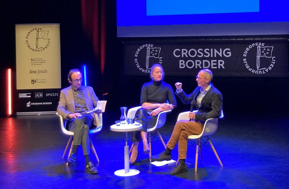 Foto van de auteur, interviewer en vertaler op het podium van Crossing Border.