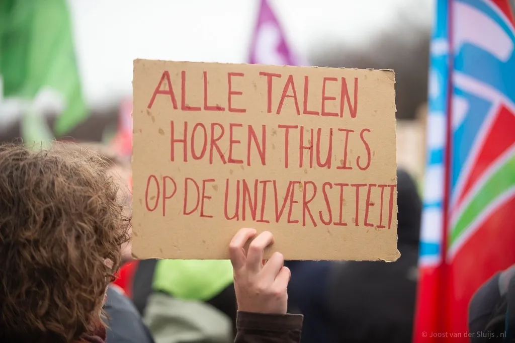 protestbord tijdens protesten Malieveld met de tekst "Alle talen horen thuis op de universiteit"